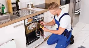 Technician inspecting a dishwasher with its front panel removed
