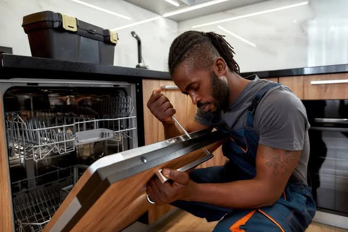 Technician examining the door of an open dishwasher