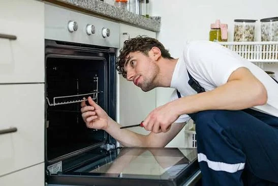 Technician examining the inside of a built-in oven